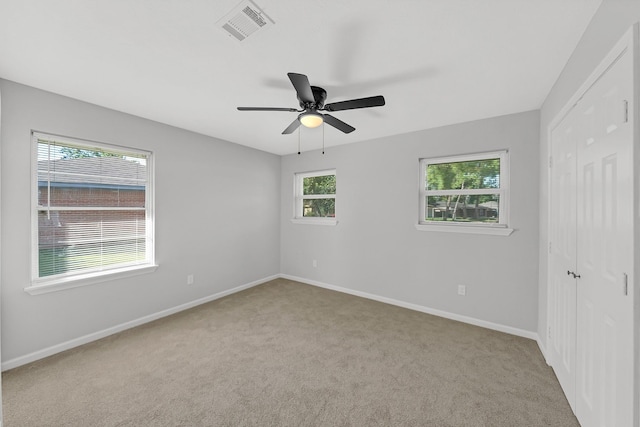 unfurnished room featuring light colored carpet and ceiling fan