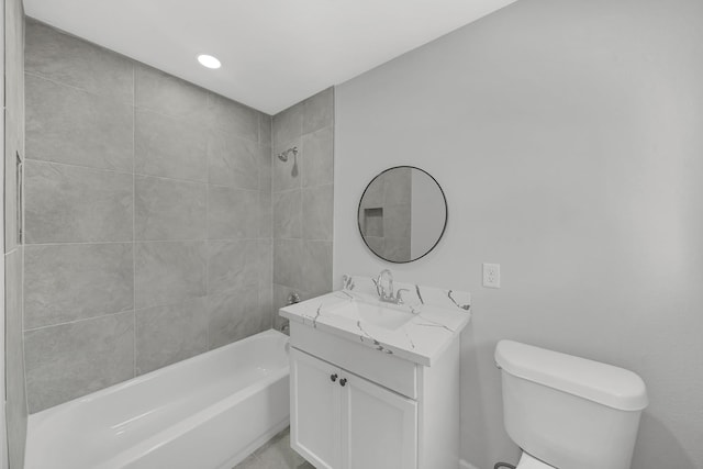 full bathroom featuring tiled shower / bath combo, toilet, and vanity