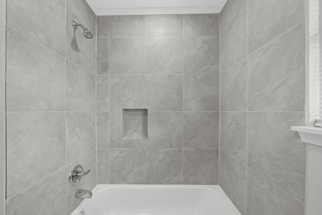 bathroom with tiled shower / bath and ornamental molding