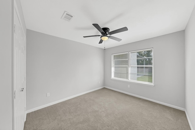 empty room featuring ceiling fan and light colored carpet