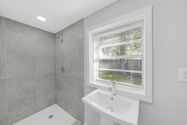 bathroom with sink, plenty of natural light, and tiled shower