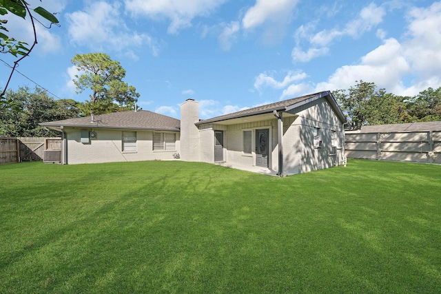 rear view of property featuring a lawn and a patio