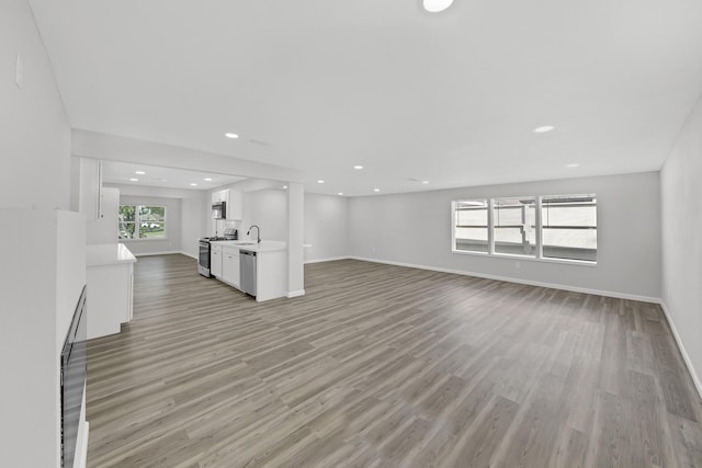 unfurnished living room with sink and light wood-type flooring