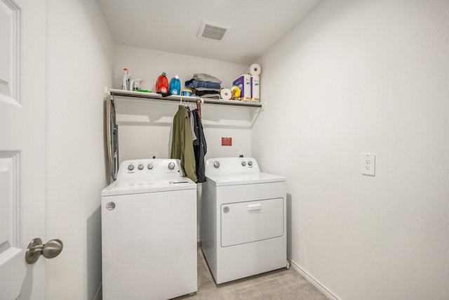 washroom featuring light tile patterned floors and washer and clothes dryer