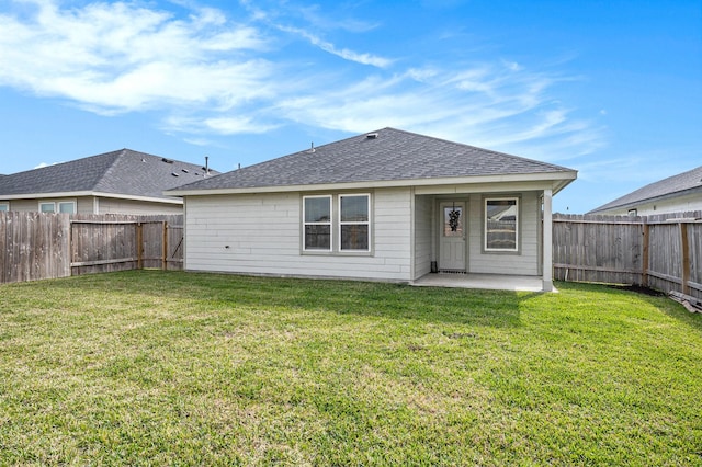 rear view of property with a yard and a patio