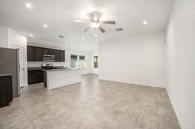 kitchen featuring a center island with sink, sink, ceiling fan, appliances with stainless steel finishes, and dark brown cabinetry