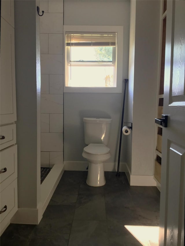 bathroom featuring toilet and tiled shower