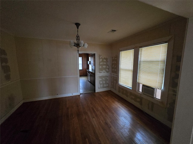 unfurnished dining area featuring a notable chandelier, cooling unit, and dark wood-type flooring