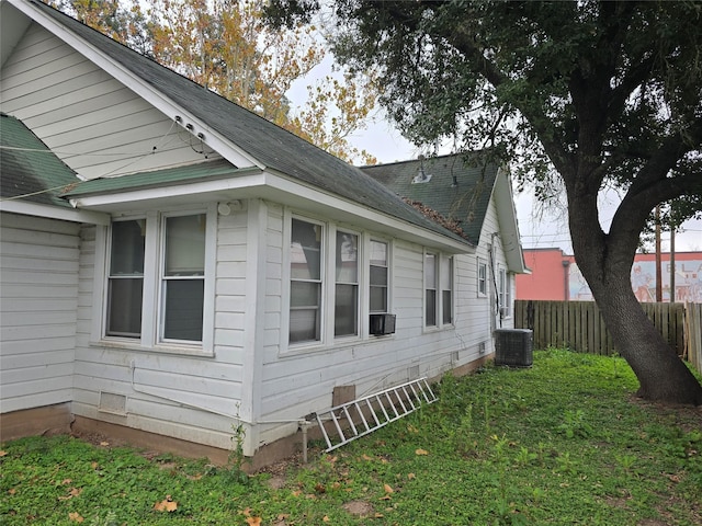 view of property exterior featuring a lawn and central AC