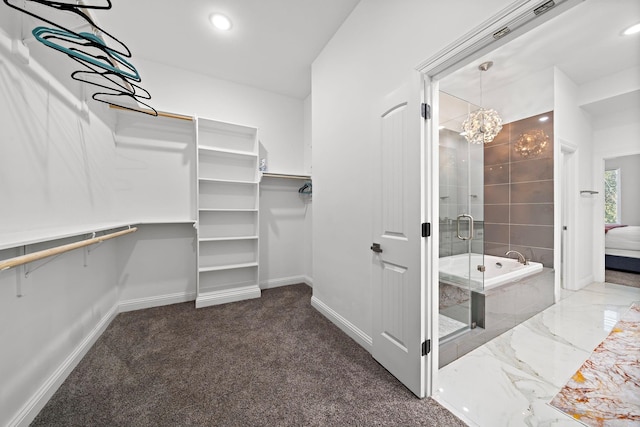 walk in closet featuring carpet and a notable chandelier