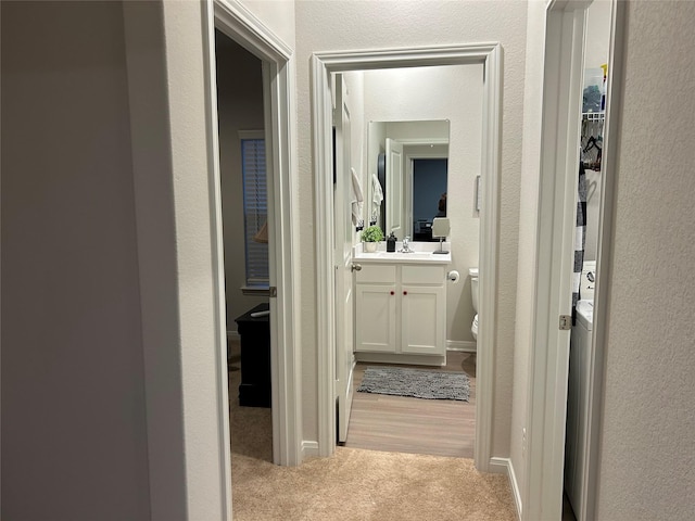 hallway featuring light colored carpet