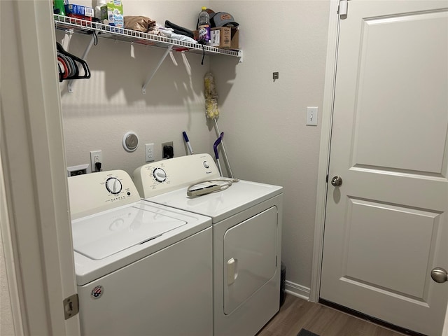 clothes washing area with dark wood-type flooring and washer and dryer