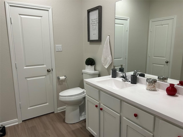 bathroom with vanity, hardwood / wood-style floors, and toilet