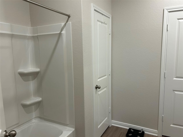 bathroom with hardwood / wood-style flooring and shower / bathing tub combination