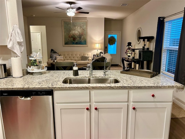 kitchen with sink, white cabinetry, light stone counters, dishwasher, and ceiling fan