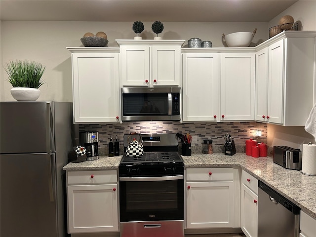 kitchen with white cabinetry, appliances with stainless steel finishes, and tasteful backsplash