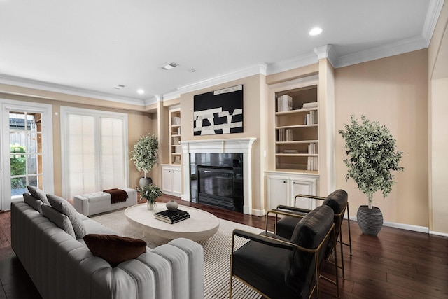 living room with built in shelves, dark hardwood / wood-style flooring, and ornamental molding