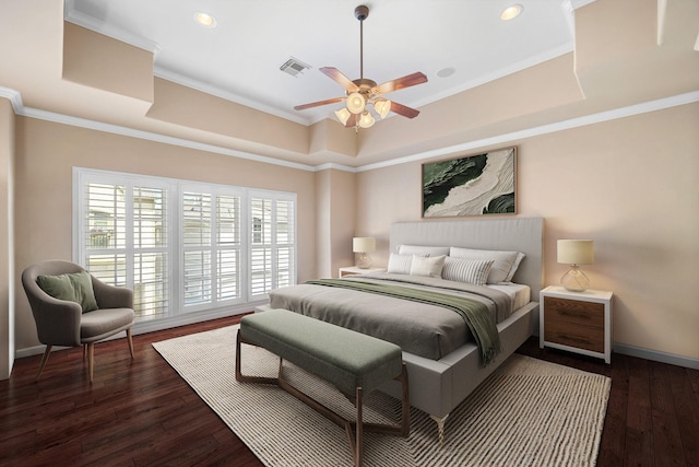 bedroom with ceiling fan, crown molding, dark wood-type flooring, and a tray ceiling