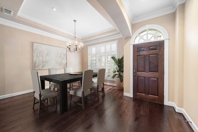 dining space featuring dark hardwood / wood-style flooring, an inviting chandelier, and crown molding