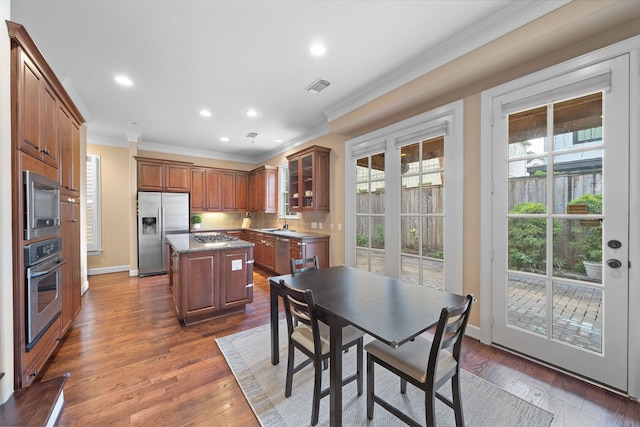 kitchen with a center island, dark hardwood / wood-style flooring, a healthy amount of sunlight, and appliances with stainless steel finishes