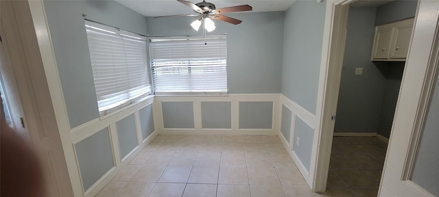 unfurnished dining area with ceiling fan and light tile patterned floors