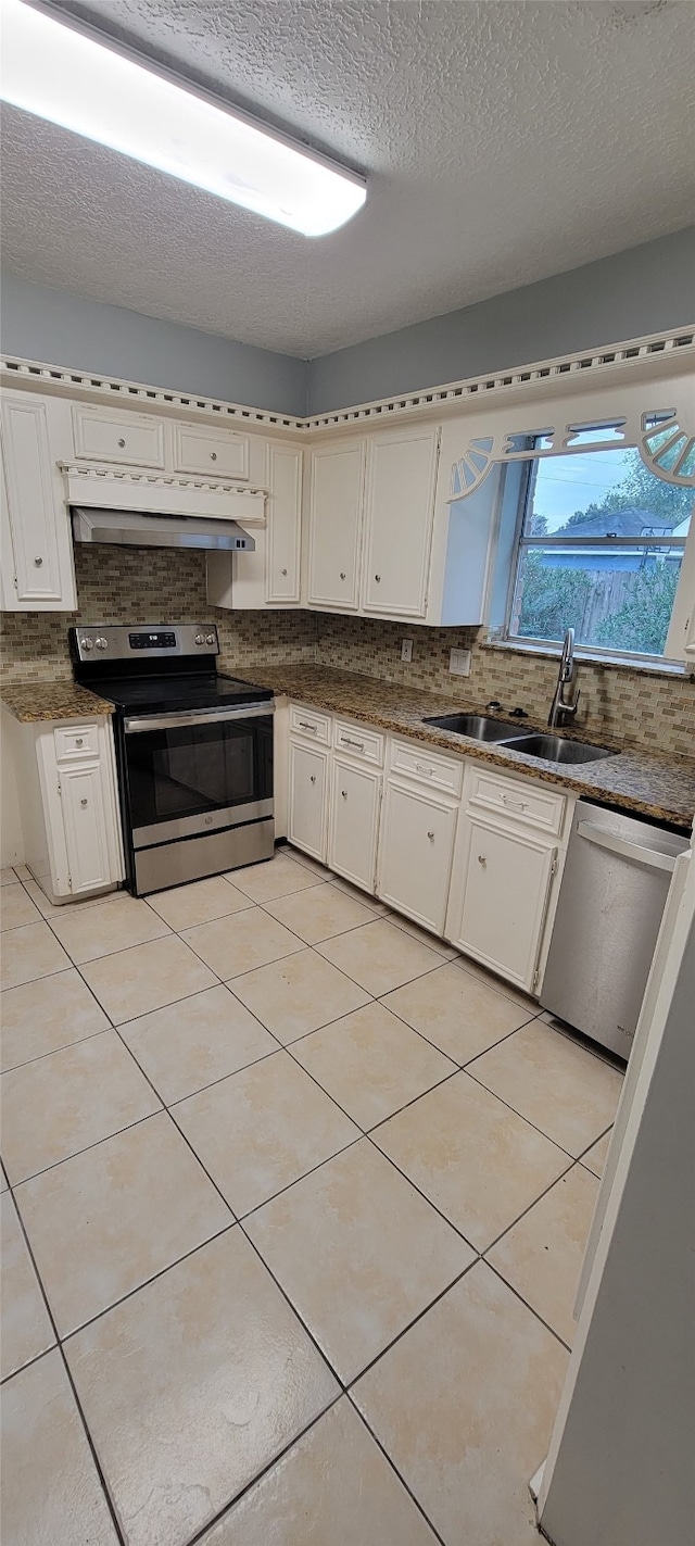 kitchen with decorative backsplash, stainless steel appliances, exhaust hood, sink, and light tile patterned flooring