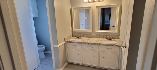 bathroom featuring tile patterned flooring, vanity, and toilet