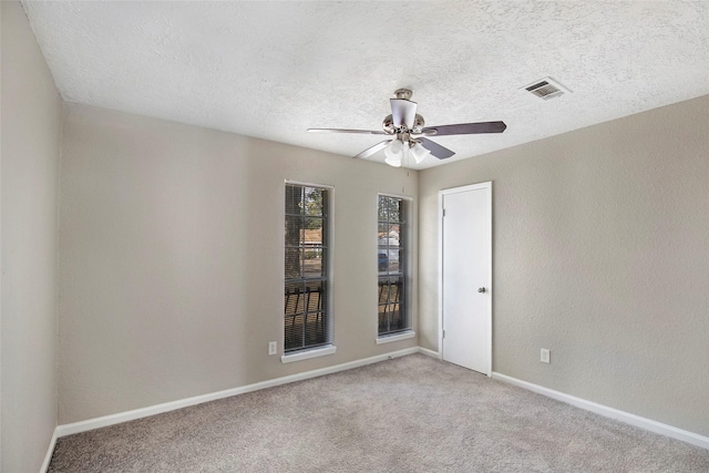 unfurnished room with a textured ceiling, carpet floors, and ceiling fan