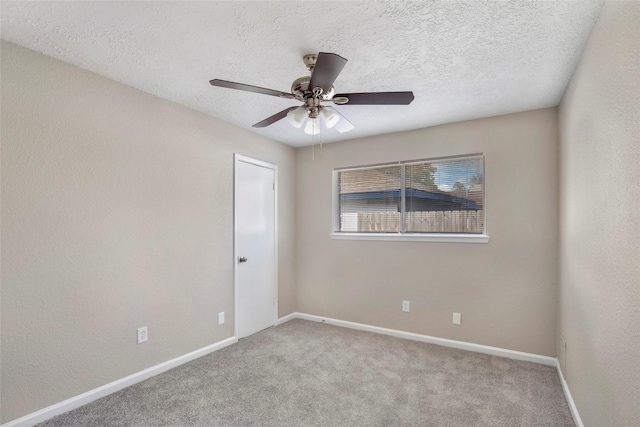 spare room featuring ceiling fan, light colored carpet, and a textured ceiling