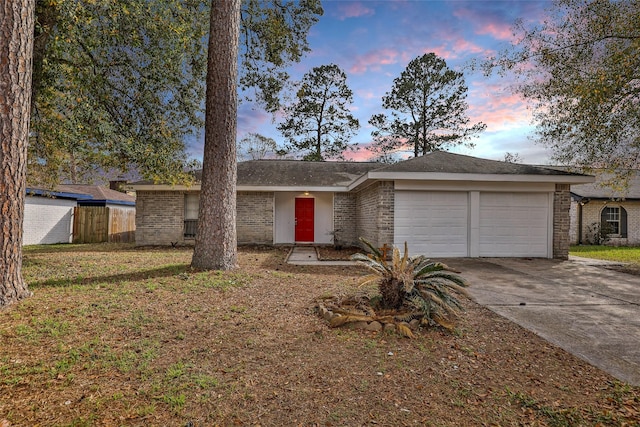 single story home with a garage and a lawn