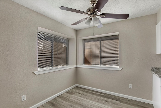 empty room featuring hardwood / wood-style flooring, ceiling fan, and a textured ceiling