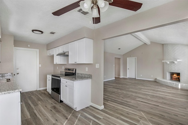 kitchen with light hardwood / wood-style flooring, white cabinets, stainless steel electric range, and a brick fireplace