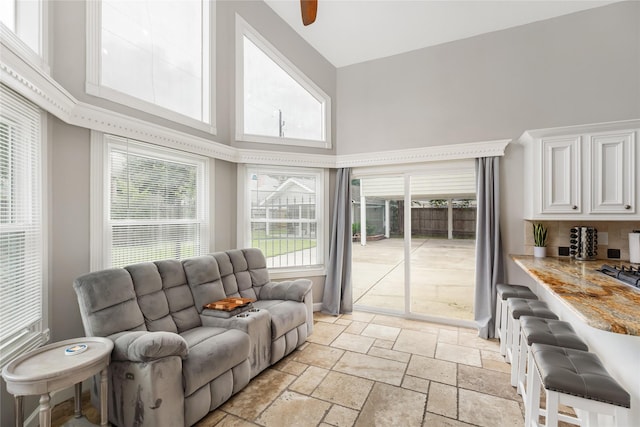 living room with a high ceiling and ceiling fan