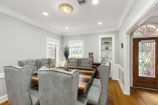 dining space featuring crown molding and dark wood-type flooring