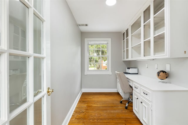 office space featuring light hardwood / wood-style flooring and built in desk