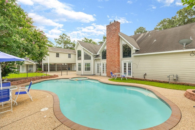 view of pool featuring a patio area, an in ground hot tub, and french doors