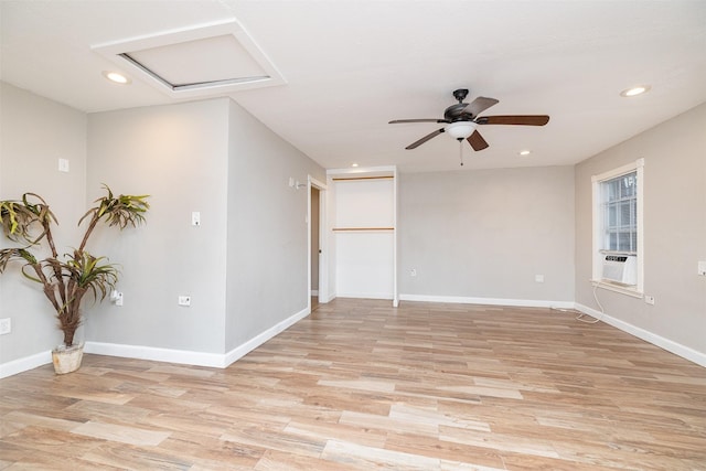 empty room featuring light wood-type flooring, ceiling fan, and cooling unit