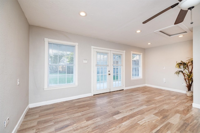 empty room with ceiling fan, light hardwood / wood-style flooring, and french doors