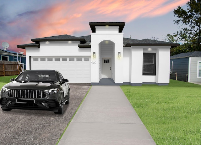 prairie-style home featuring a lawn and a garage