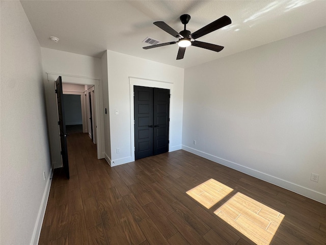 unfurnished bedroom featuring dark hardwood / wood-style flooring, ceiling fan, and a closet