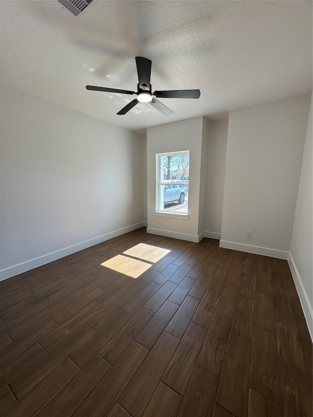 unfurnished room with a textured ceiling, dark wood-type flooring, and ceiling fan