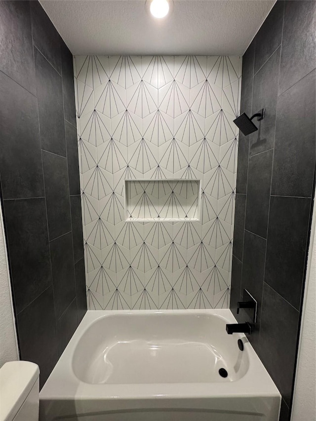 bathroom with shower / tub combination, toilet, and a textured ceiling