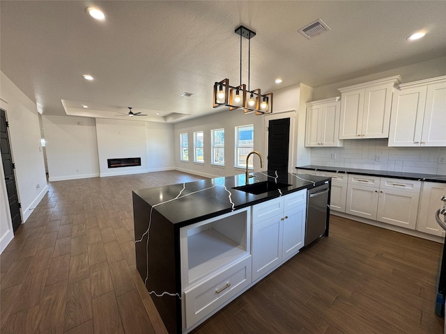 kitchen with sink, stainless steel dishwasher, white cabinets, and decorative backsplash