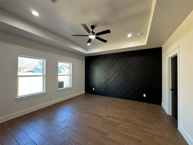 unfurnished room featuring a tray ceiling and ceiling fan