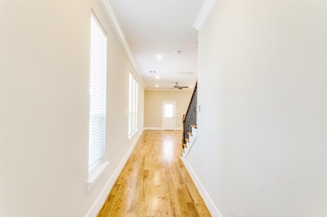 hall with crown molding and light wood-type flooring