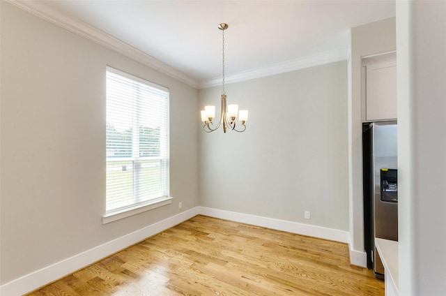 unfurnished dining area with hardwood / wood-style floors, crown molding, and a notable chandelier