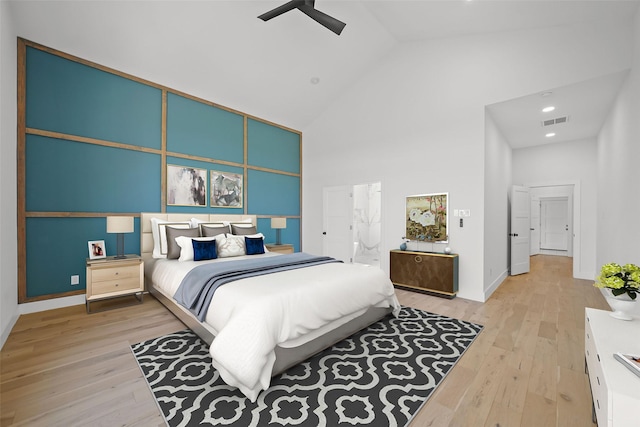 bedroom with ceiling fan, light wood-type flooring, and high vaulted ceiling