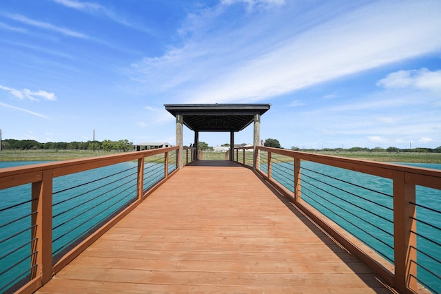 view of dock with a gazebo and a water view