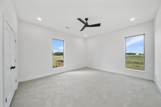 carpeted spare room featuring ceiling fan