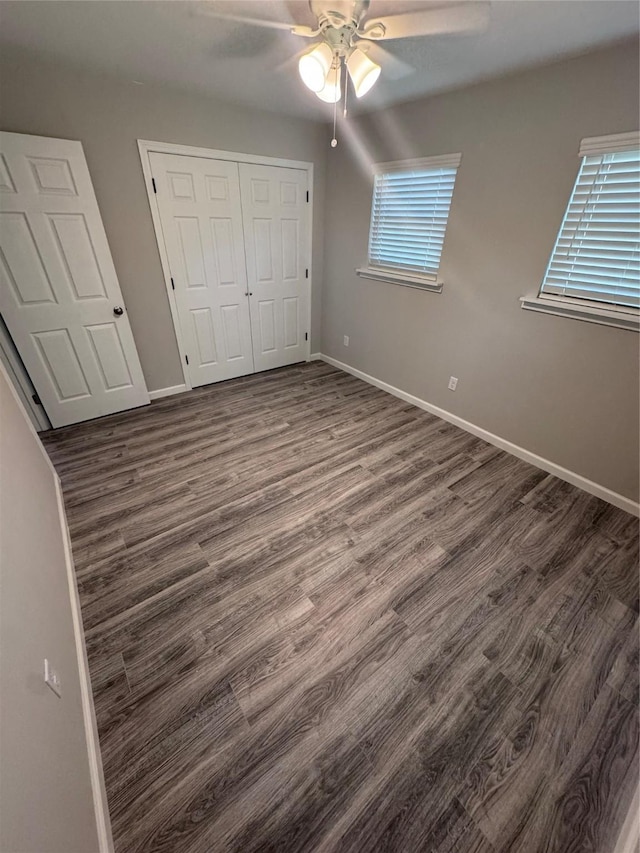 unfurnished bedroom with ceiling fan, dark hardwood / wood-style flooring, and a closet